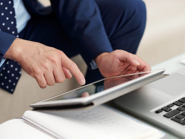 Hands of business executive using application on tablet computer